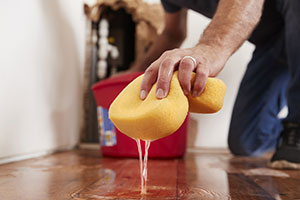A man cleaning up a plumbing disaster and thinking about water claims
