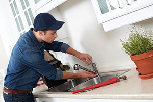 self-employed plumber fixing sink
