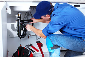 self-employed plumber plumbing in a sink
