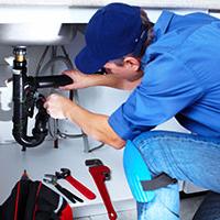 self-employed plumber plumbing in a sink