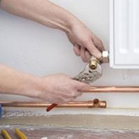 A plumber that has taken on self-employment fixing a radiator
