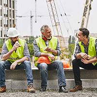 Happy tradespeople eating sandwiches