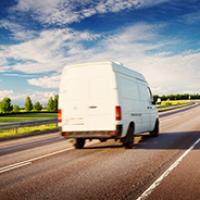 White van travelling down road