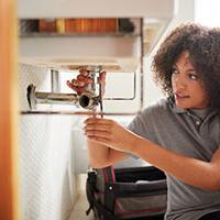 Young female plumber fixing a sink - Nextdoor