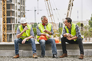 Happy tradespeople eating sandwiches
